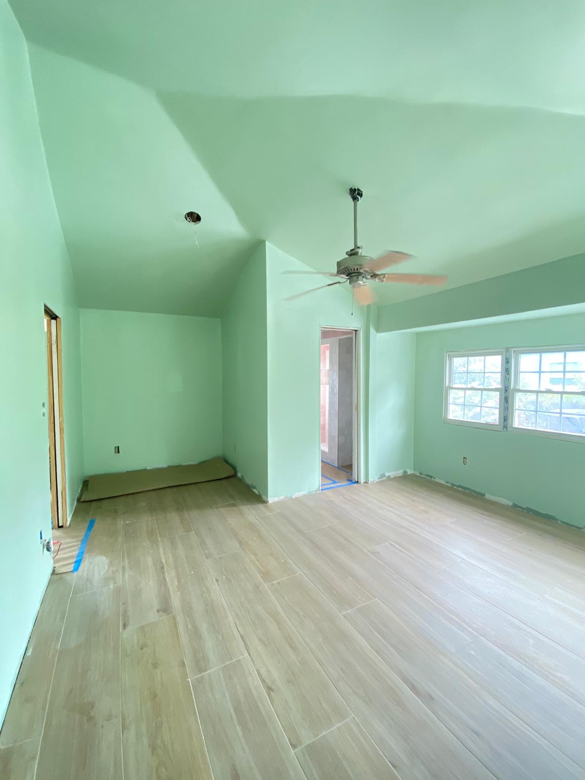 Bedroom with mint green walls and vaulted ceiling
