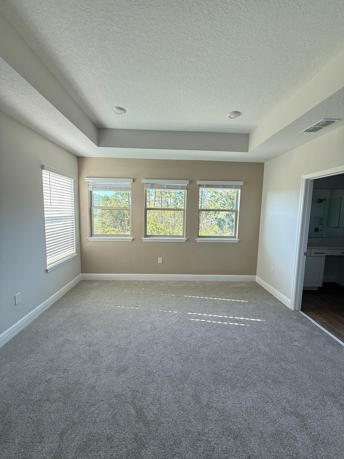 Master bedroom with tray ceiling in beige