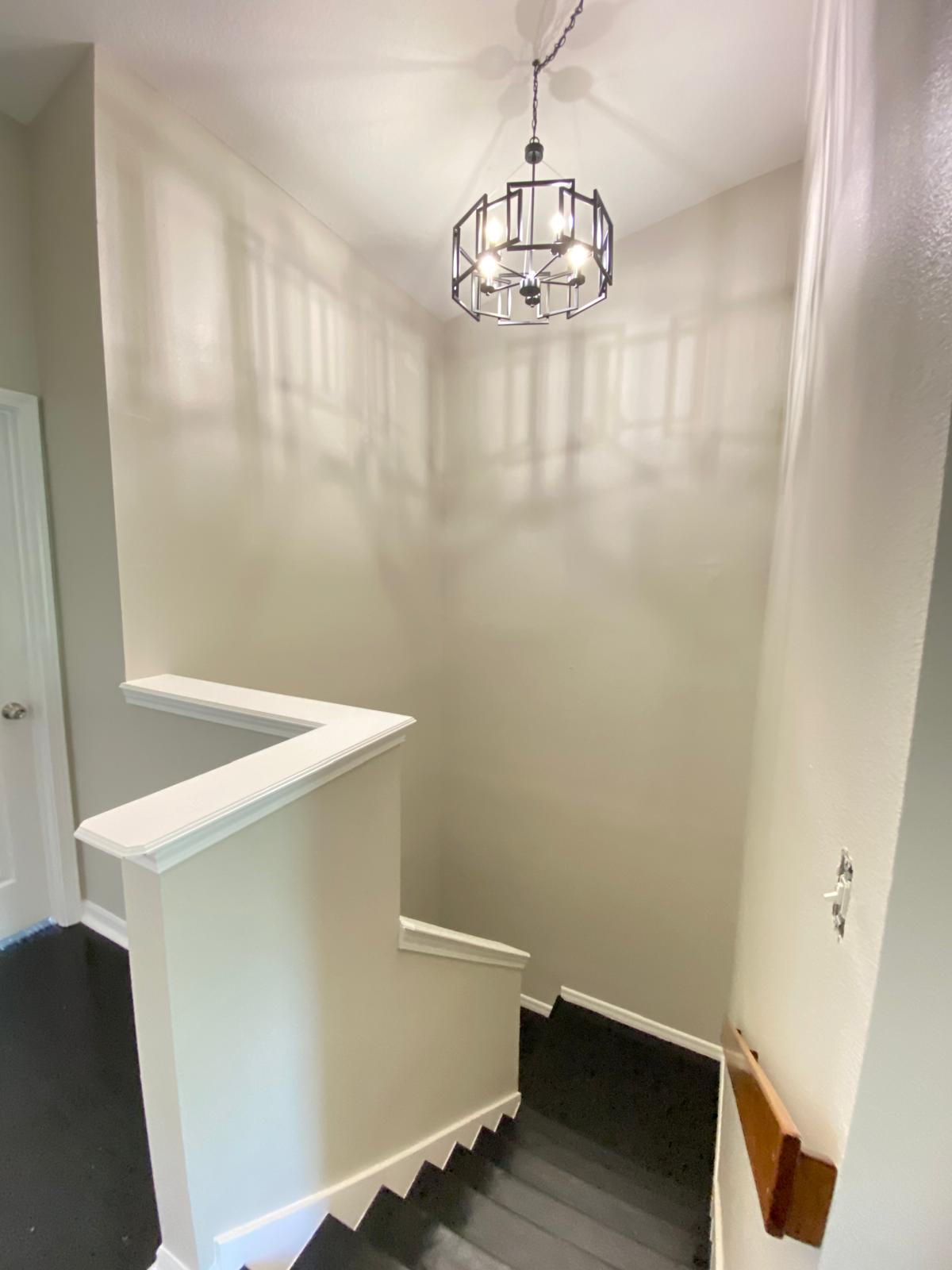 Stairwell white with vaulted ceiling and chandelier